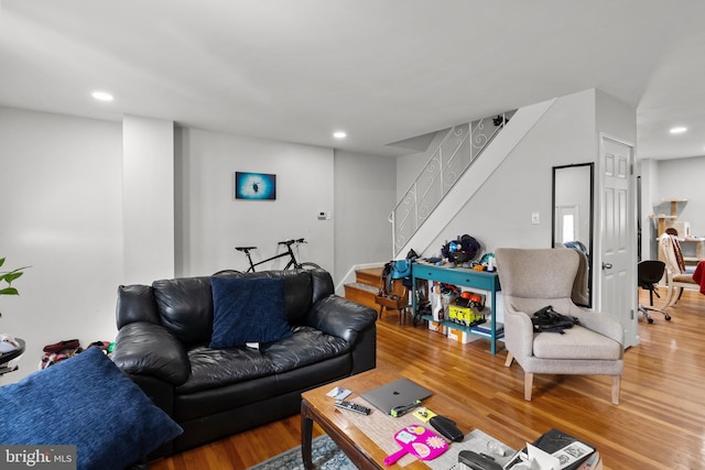 living area with recessed lighting, stairway, and wood finished floors