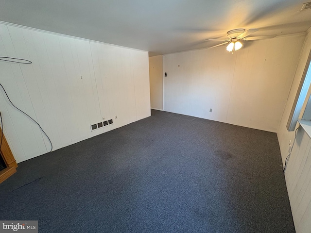 empty room featuring visible vents, ceiling fan, and carpet flooring