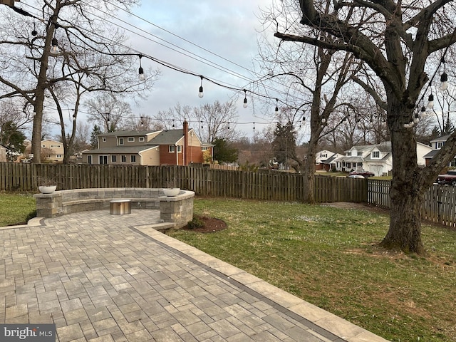 view of yard featuring a residential view, a fenced backyard, and a patio area