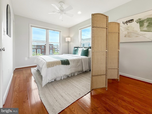 bedroom with wood finished floors, a ceiling fan, and baseboards