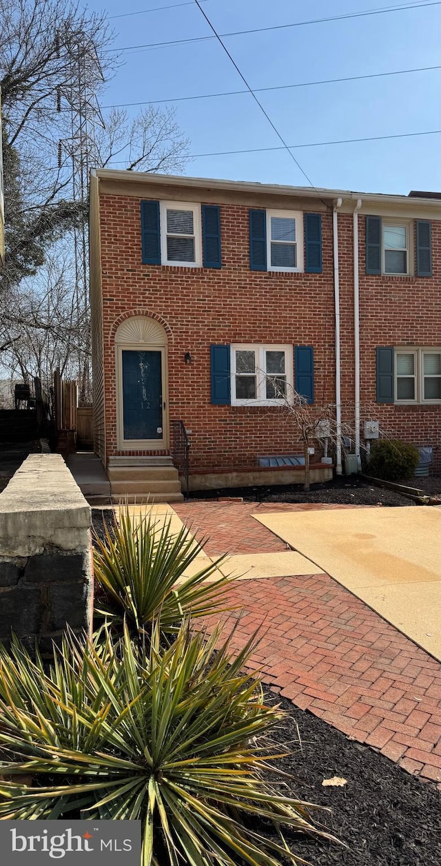 view of front of house featuring entry steps, fence, and brick siding