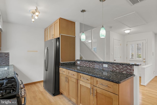 kitchen with visible vents, stainless steel appliances, light wood-style floors, a peninsula, and decorative backsplash