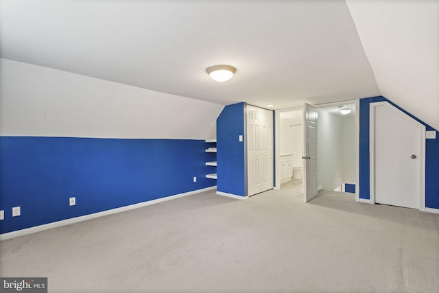 additional living space featuring baseboards, lofted ceiling, and carpet