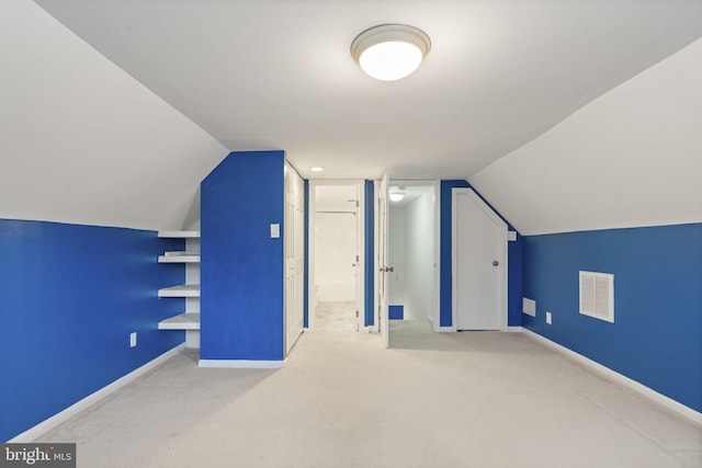 additional living space with visible vents, carpet, lofted ceiling, and baseboards