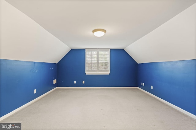 additional living space with lofted ceiling, baseboards, and carpet floors