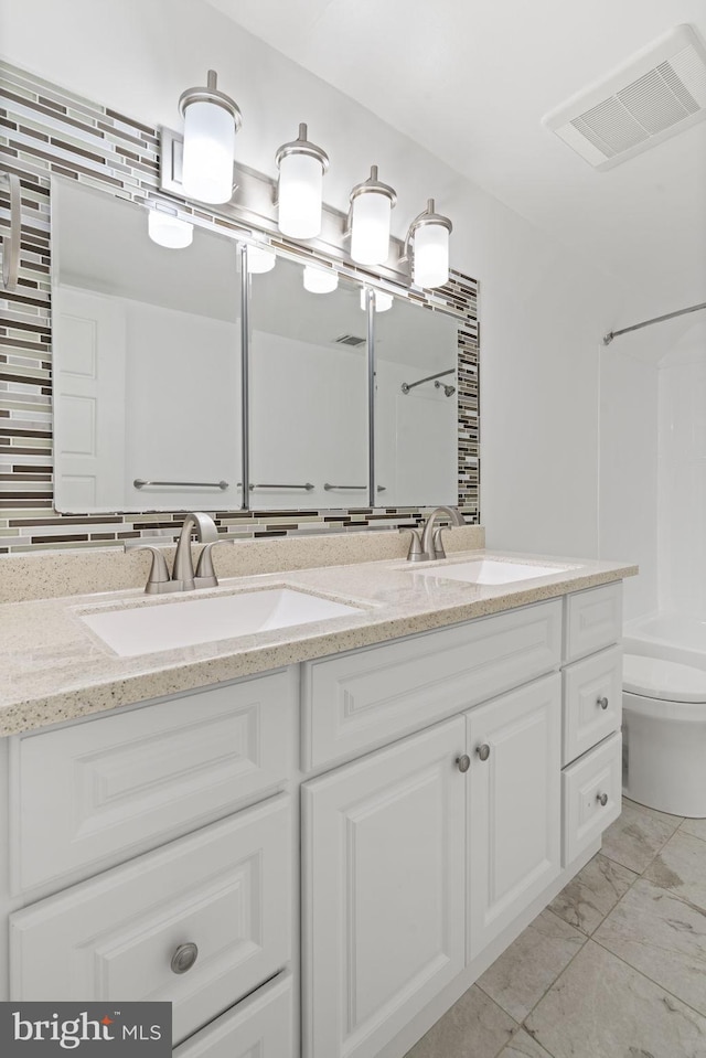 full bathroom featuring double vanity, visible vents, toilet, and a sink