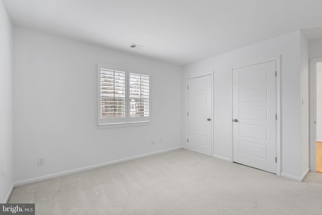 unfurnished bedroom featuring visible vents, baseboards, and carpet flooring