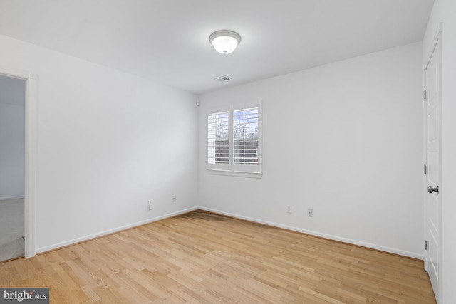 unfurnished room featuring visible vents, baseboards, and light wood-style floors