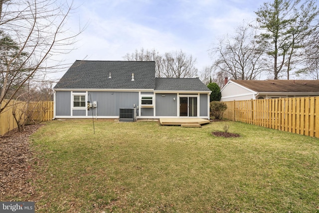 back of house with central AC unit, a lawn, a wooden deck, and a fenced backyard