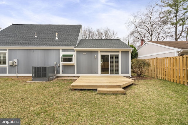 rear view of house featuring fence, cooling unit, a yard, a shingled roof, and a wooden deck