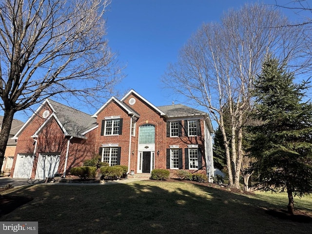 view of front facade featuring a front yard, an attached garage, and brick siding