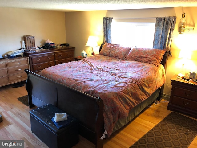 bedroom featuring a textured ceiling and wood finished floors