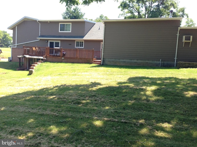 back of property featuring a lawn, a deck, and a shingled roof