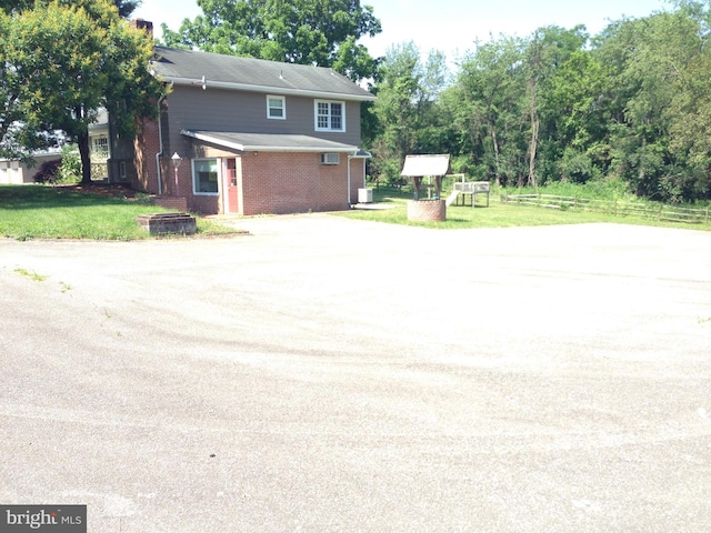 view of home's exterior featuring a yard, brick siding, and fence