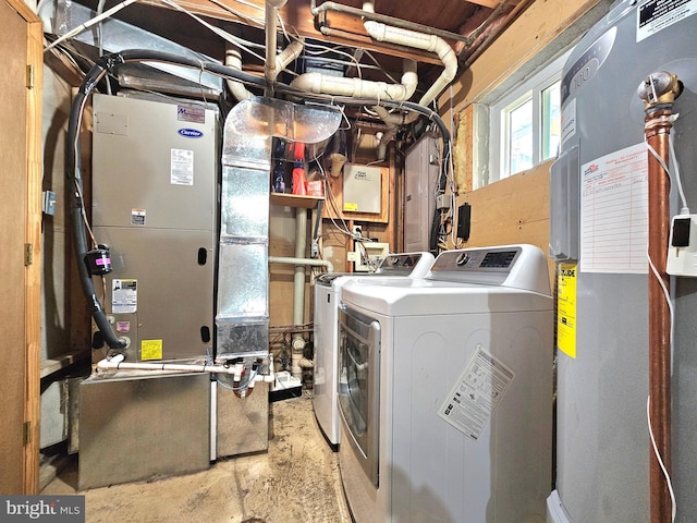 washroom featuring laundry area, heating unit, and independent washer and dryer