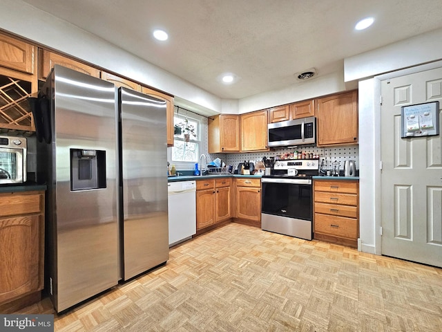 kitchen featuring dark countertops, visible vents, backsplash, and appliances with stainless steel finishes