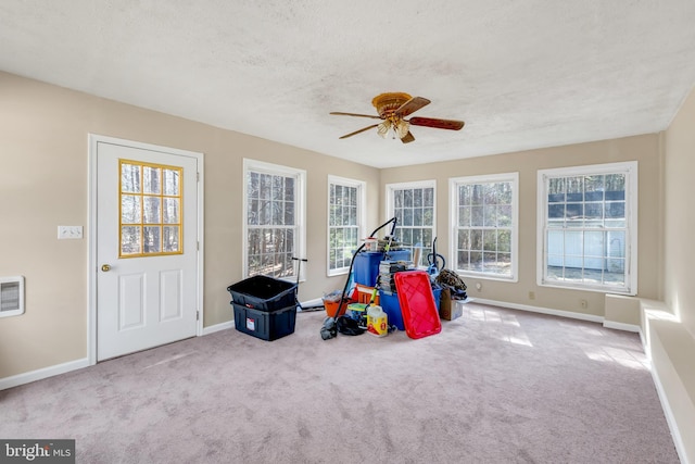 recreation room featuring carpet flooring, a textured ceiling, baseboards, and ceiling fan
