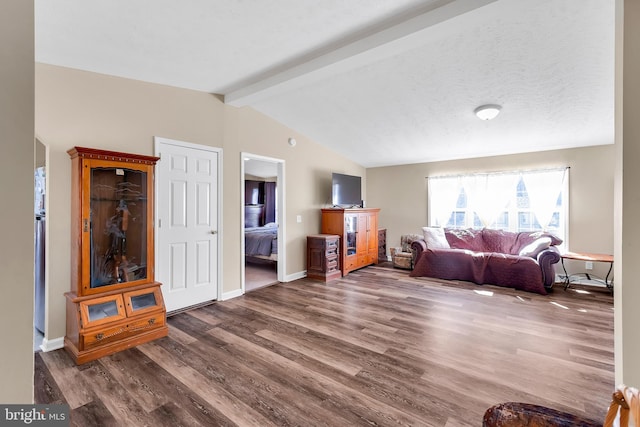 living area with lofted ceiling with beams, baseboards, a textured ceiling, and wood finished floors