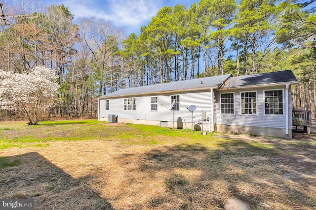 view of front facade featuring cooling unit, a front yard, and crawl space