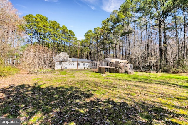 view of yard with an outbuilding and a forest view