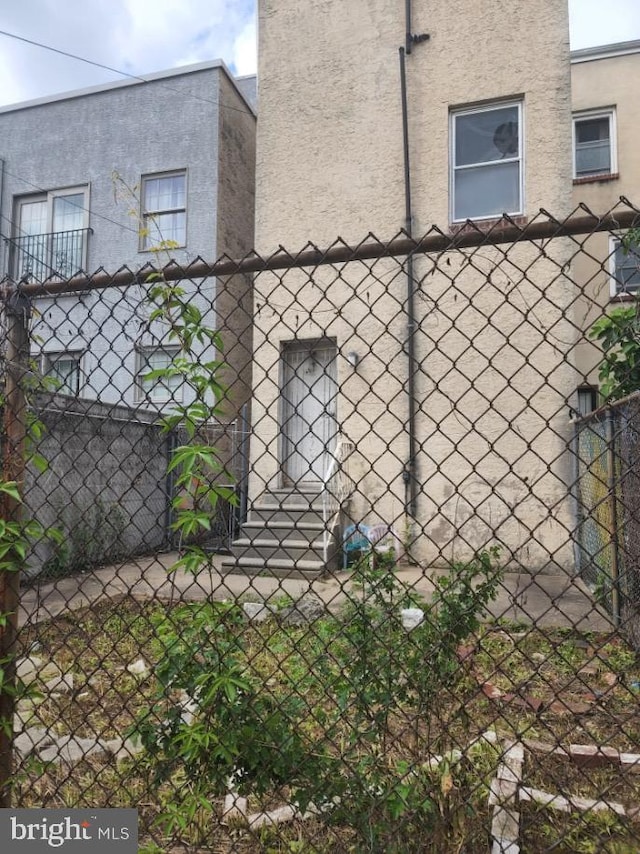 view of side of home featuring stucco siding and fence