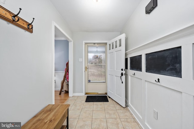 foyer featuring light tile patterned flooring and baseboards