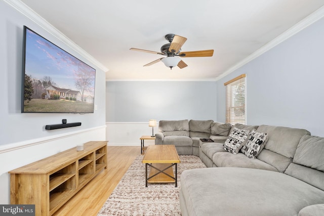 living room with wood finished floors, ornamental molding, and a ceiling fan