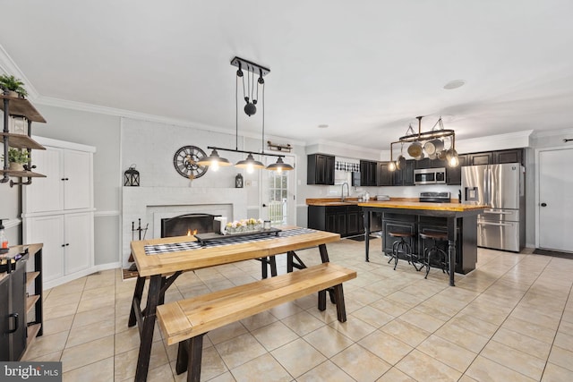 dining space with light tile patterned floors, a brick fireplace, and ornamental molding