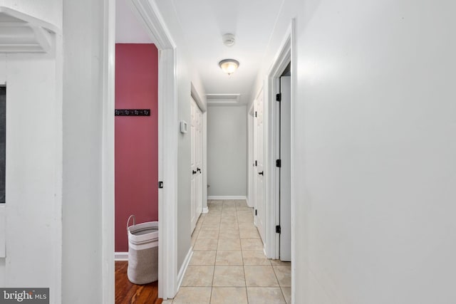 corridor with light tile patterned floors and baseboards