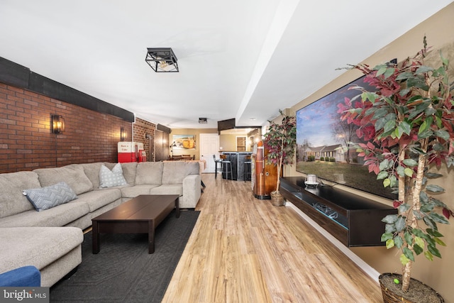 living area featuring wood finished floors and brick wall