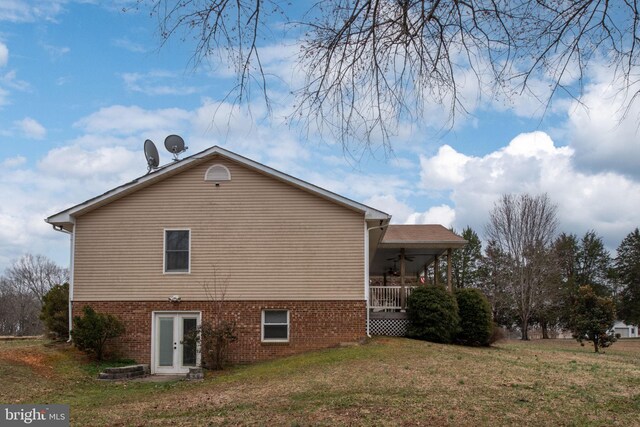 back of property with a yard and ceiling fan