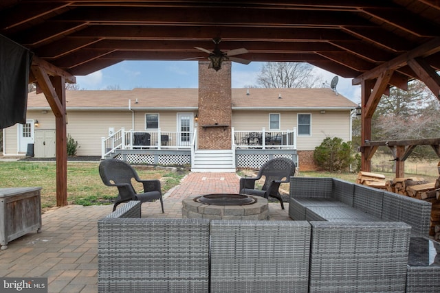 view of patio / terrace featuring an outdoor living space with a fire pit, ceiling fan, and a wooden deck