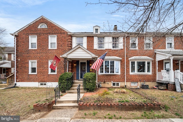 view of property featuring brick siding and a chimney