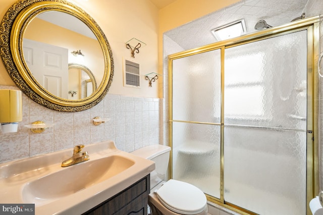 full bath featuring vanity, tile walls, toilet, and a stall shower