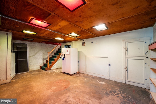 below grade area with wooden ceiling, stairway, and freestanding refrigerator