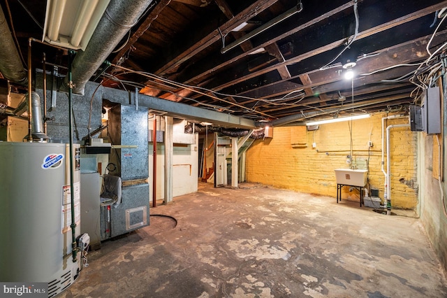 unfinished below grade area with a sink, heating unit, and water heater