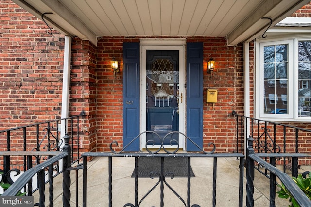 doorway to property featuring brick siding