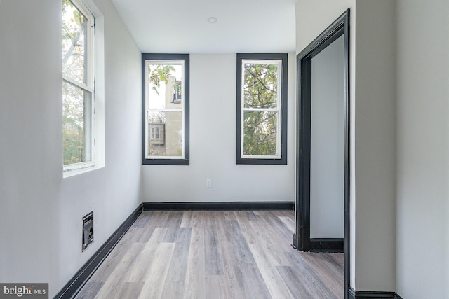 spare room with light wood-type flooring and baseboards