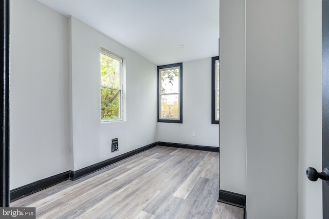 unfurnished room featuring light wood finished floors and baseboards