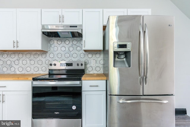 kitchen with under cabinet range hood, backsplash, stainless steel appliances, and wood counters