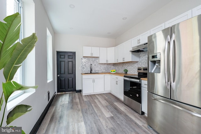 kitchen with tasteful backsplash, under cabinet range hood, stainless steel appliances, white cabinetry, and a sink