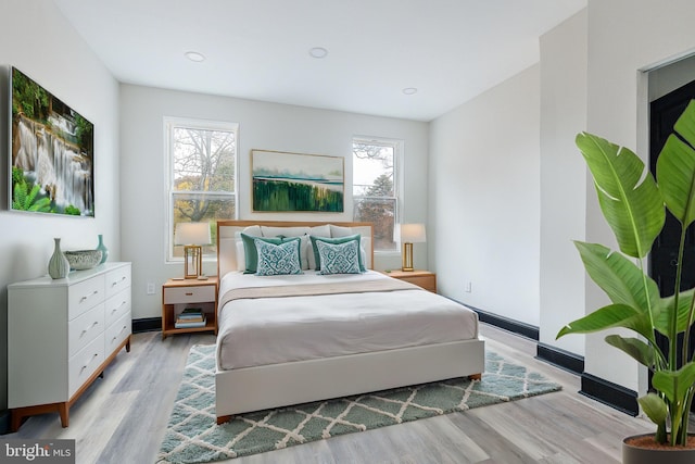 bedroom with recessed lighting, multiple windows, and light wood-type flooring