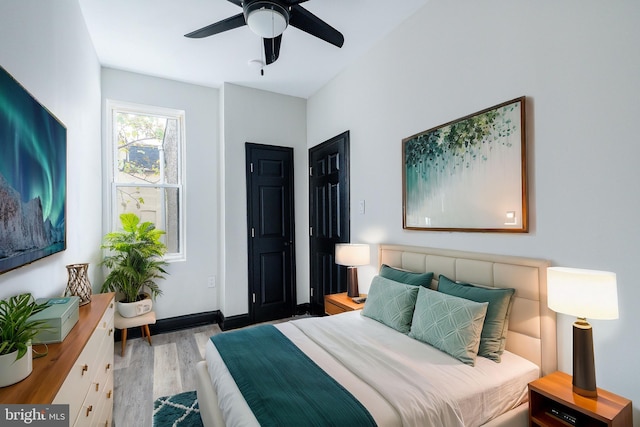 bedroom featuring wood finished floors, baseboards, and ceiling fan