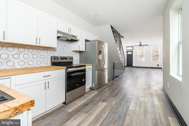 kitchen with backsplash, wooden counters, under cabinet range hood, appliances with stainless steel finishes, and white cabinets