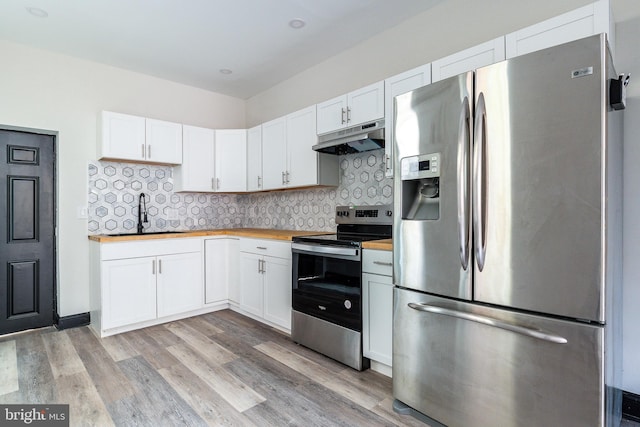 kitchen featuring a sink, butcher block countertops, stainless steel appliances, under cabinet range hood, and backsplash