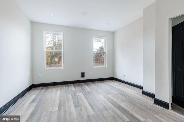 spare room featuring light wood-style floors and baseboards