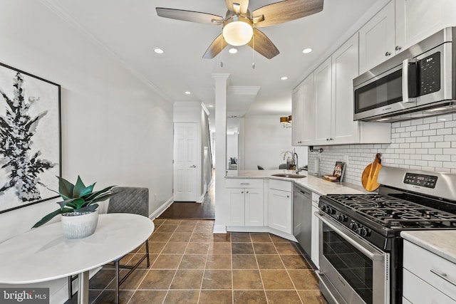 kitchen with a ceiling fan, a sink, ornamental molding, stainless steel appliances, and backsplash