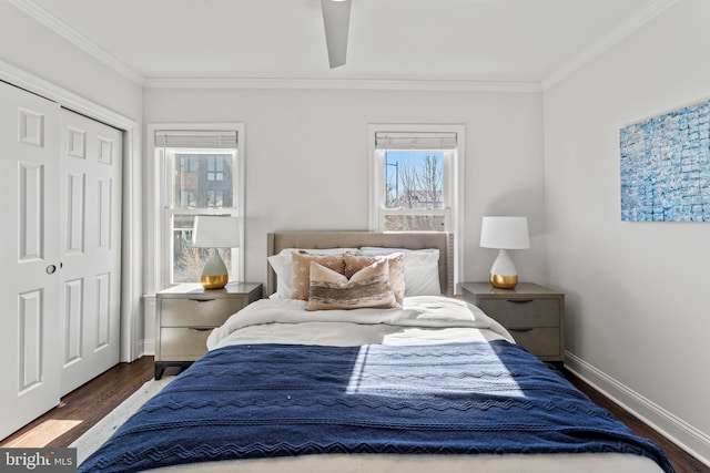 bedroom with crown molding, wood finished floors, baseboards, and a closet