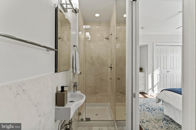 bathroom featuring a shower stall, tile walls, ensuite bathroom, and ornamental molding