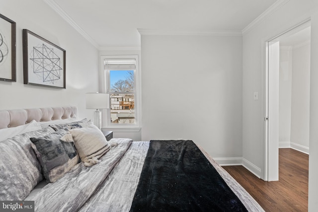 bedroom with dark wood-style floors, crown molding, and baseboards